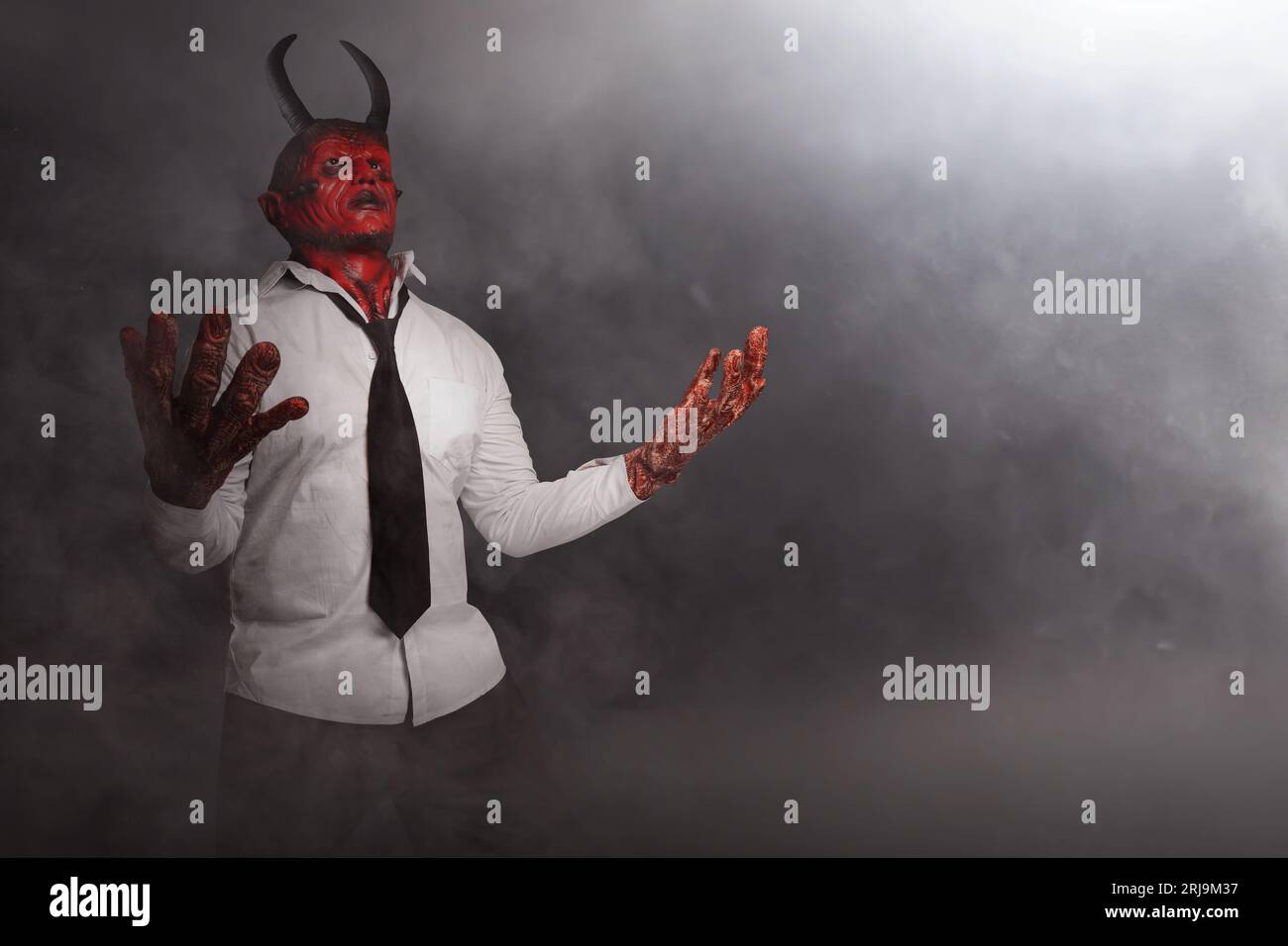 Devilman is standing in the dark background. Scary demon Halloween concept Stock Photo