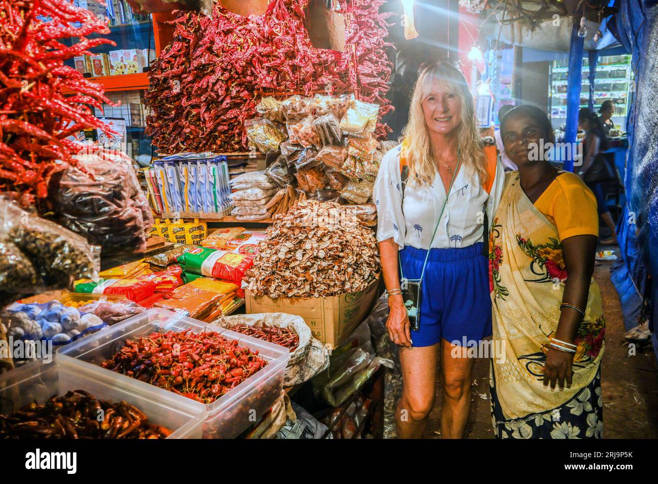 Margao, South Goa, India. 22nd Aug, 2023. a tourist poses with a local spice seller in the Narrow passage ways selling anything imaginable in the busy and colourful market at the city of Margao, South India.Paul Quezada-Neiman/Alamy Live News Credit: Paul Quezada-Neiman/Alamy Live News Stock Photo