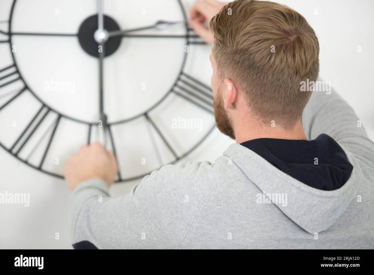 man moving the hands on a clock Stock Photo Alamy