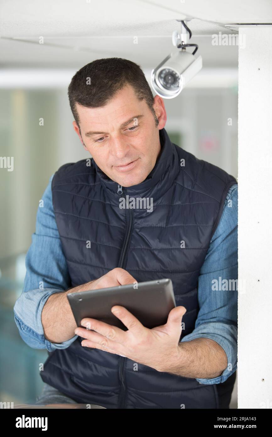 technician with tablet pc by a cctv camera Stock Photo