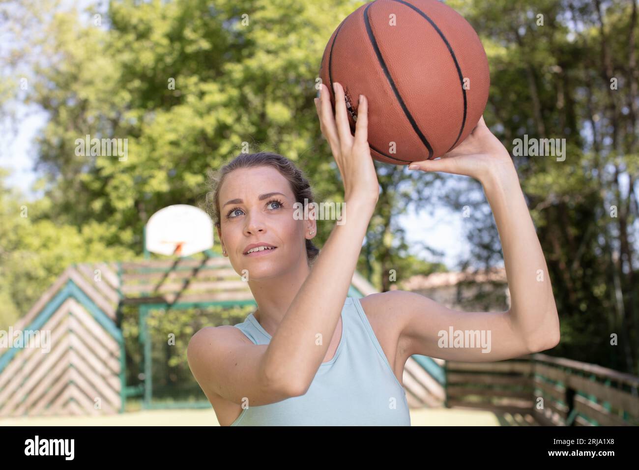 young woman ready to throw basketball into loop Stock Photo