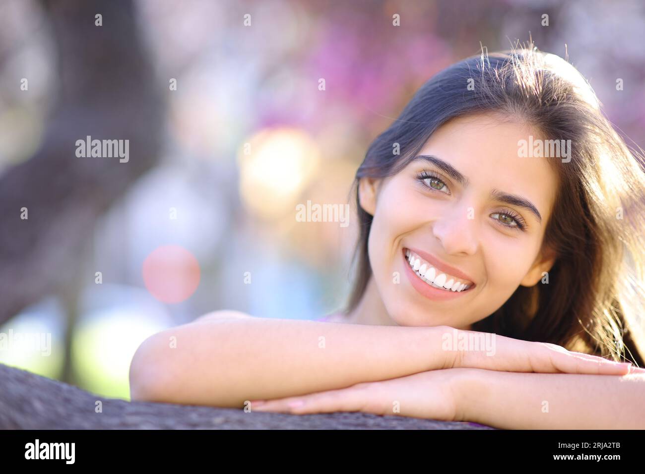 Front view portrait of a happy woman with white smile in a park Stock Photo
