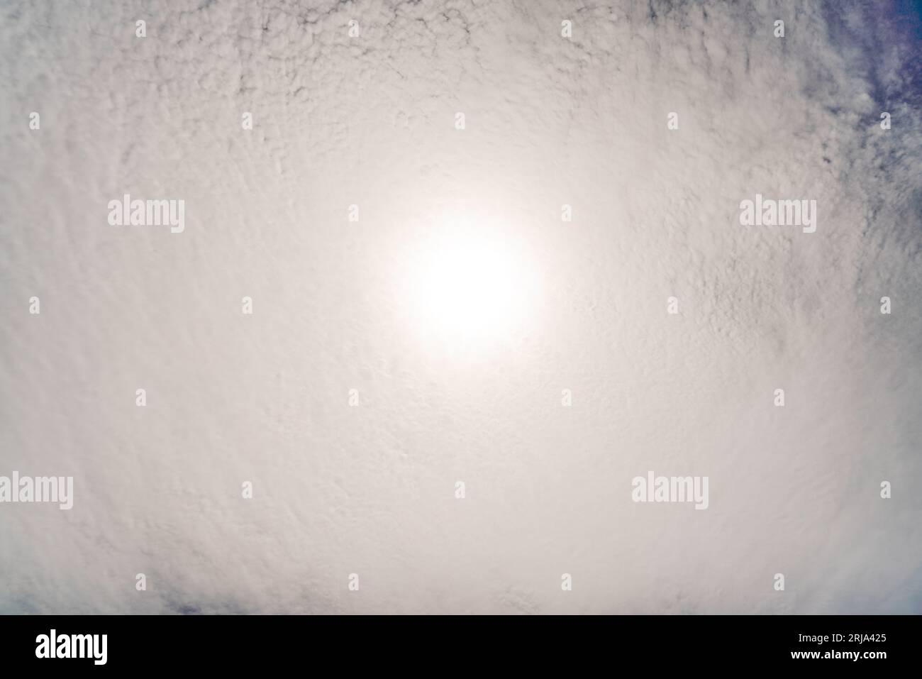 Fluffy clouds in the blue sky. The sun shines through them Stock Photo ...