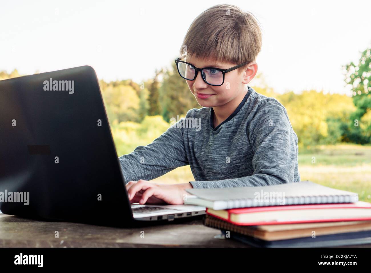 Intelligent junior student in square glasses smiling while studying