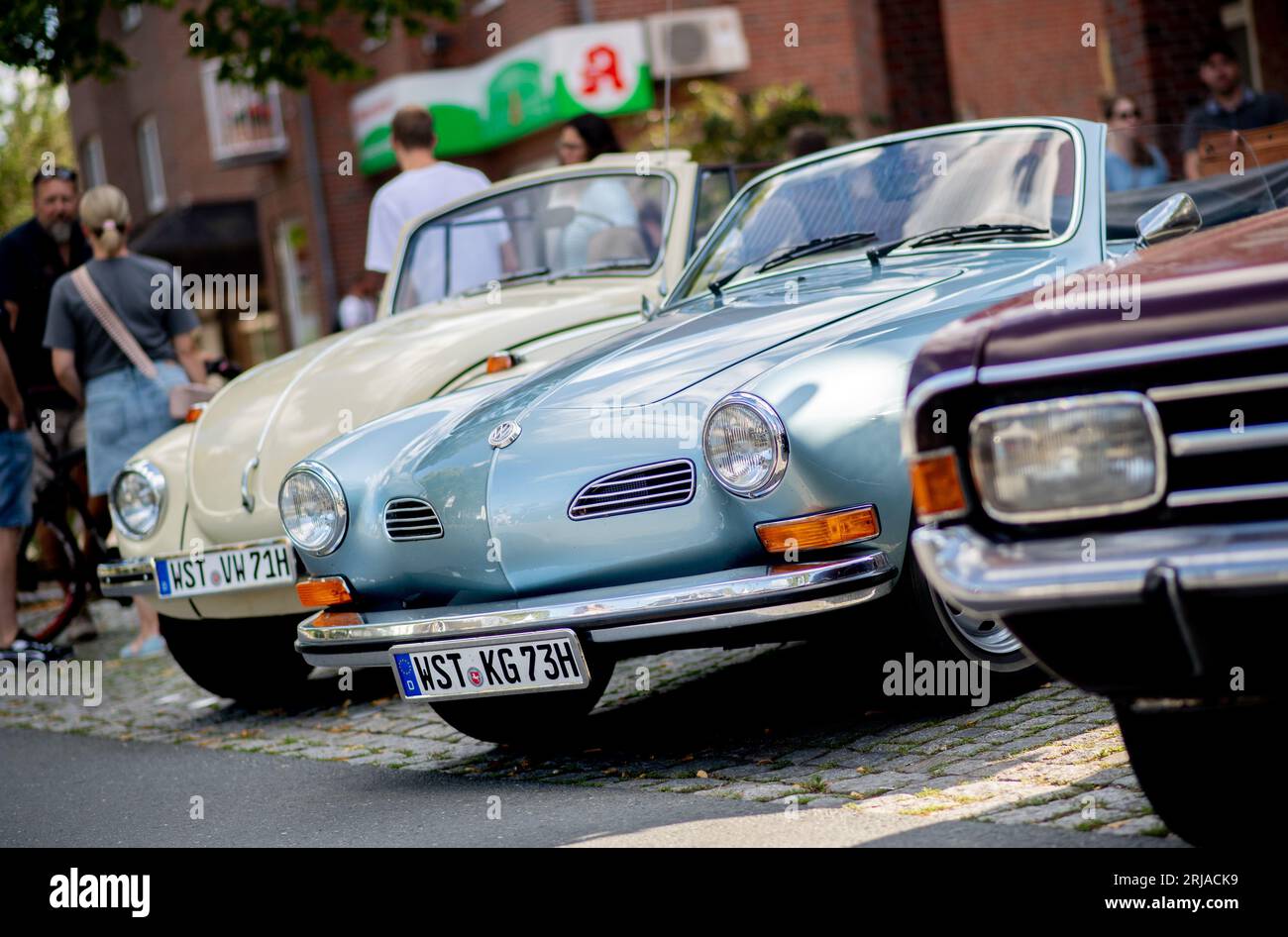 Rastede, Germany. 20th Aug, 2023. A Karmann Ghia (M) and a Volkswagen Beetle are parked at a young and oldtimer meeting in the town center. Credit: Hauke-Christian Dittrich/dpa/Alamy Live News Stock Photo