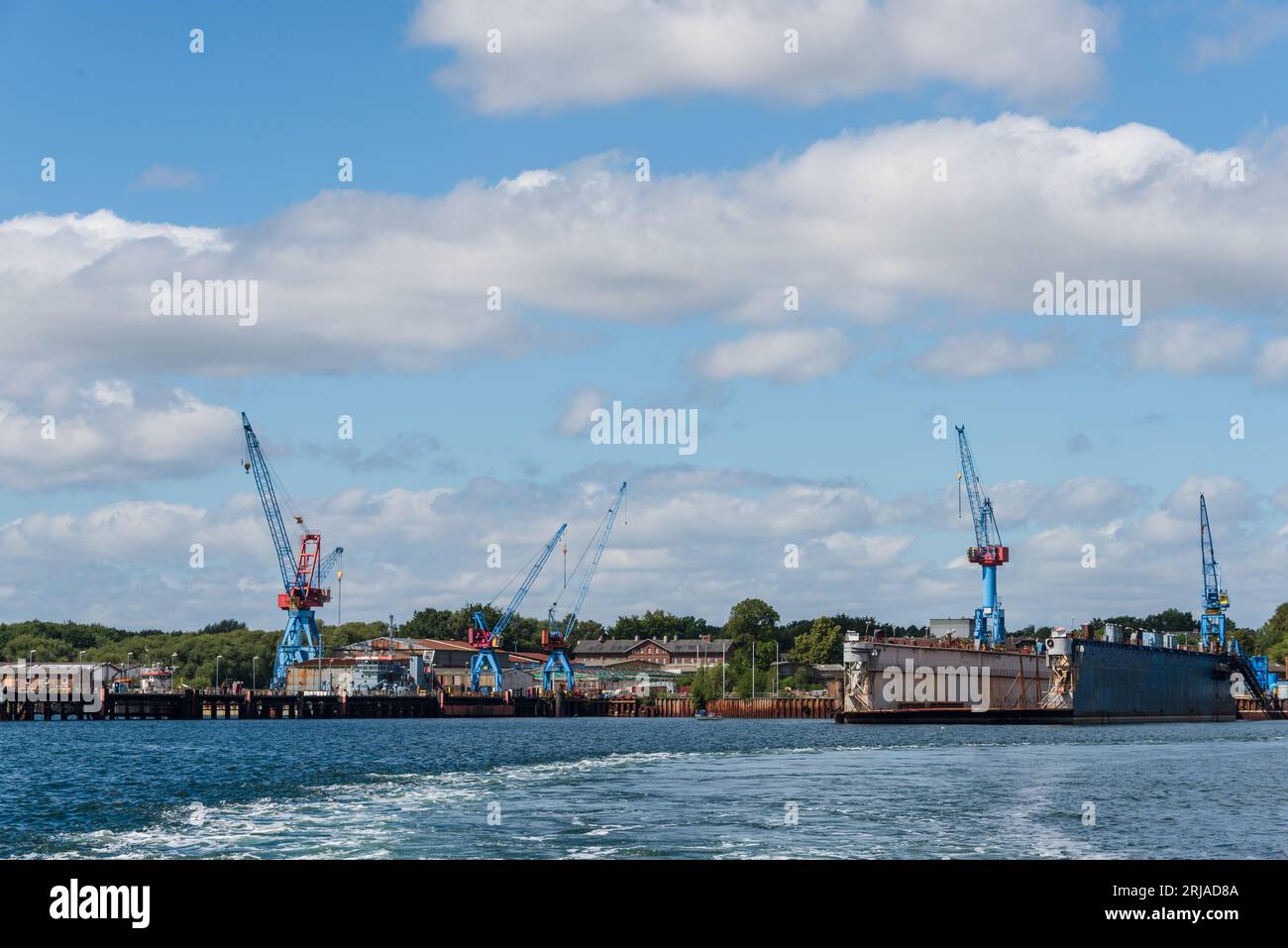 Ein Werftgelände mit Hafenkränen und einem Schwimmdock in Friedrichsort an der Kieler Förde Stock Photo