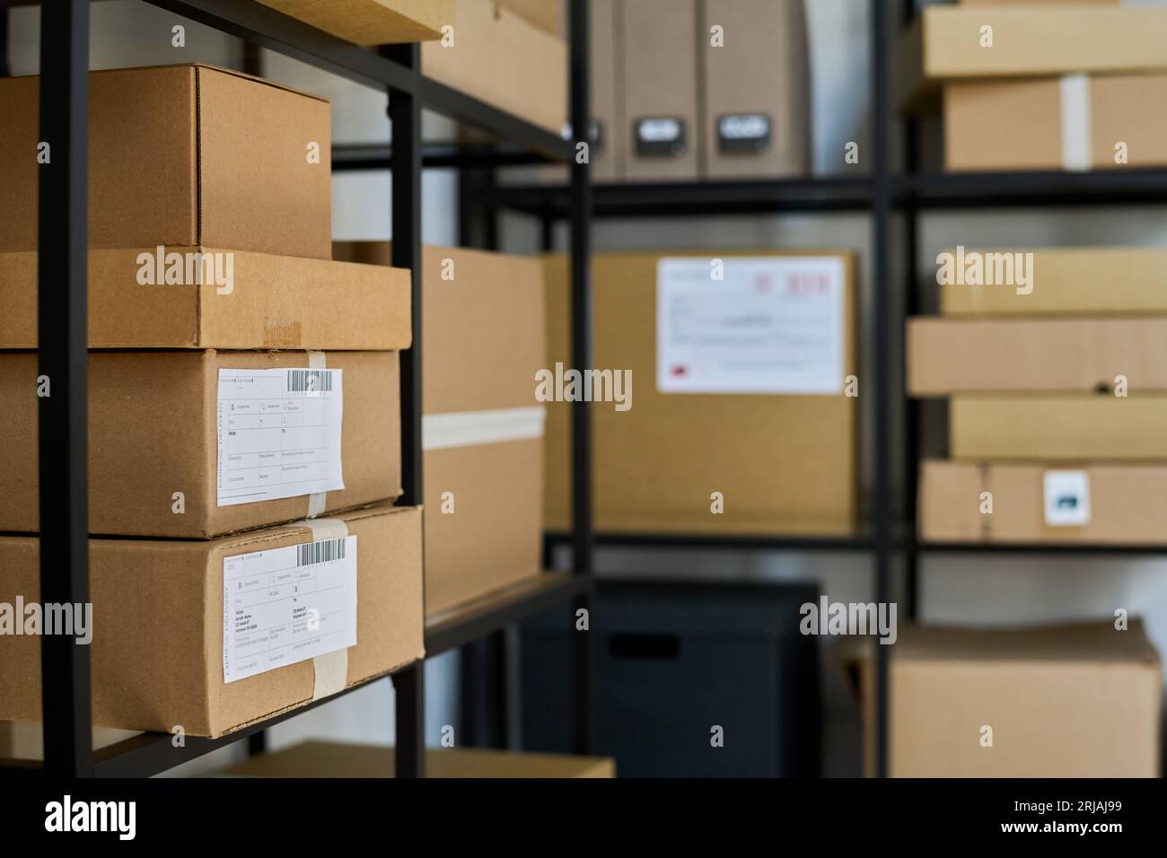 Focus on side shelf with big and medium sized cardboard packed boxes ...