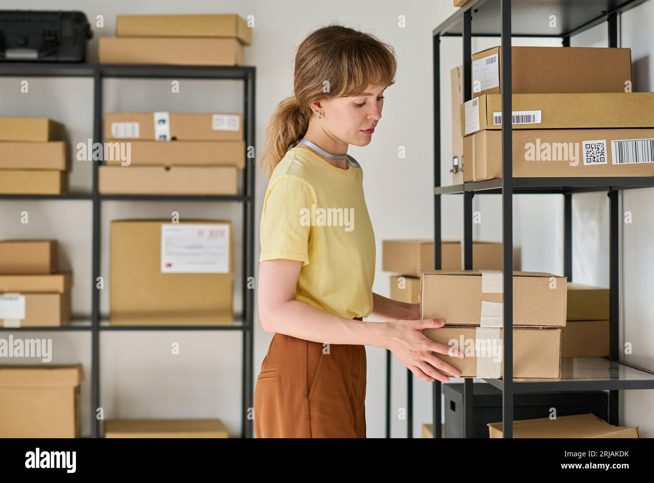 Asian guy organizing boxes with supplies on shelves Stock Photo by DC_Studio