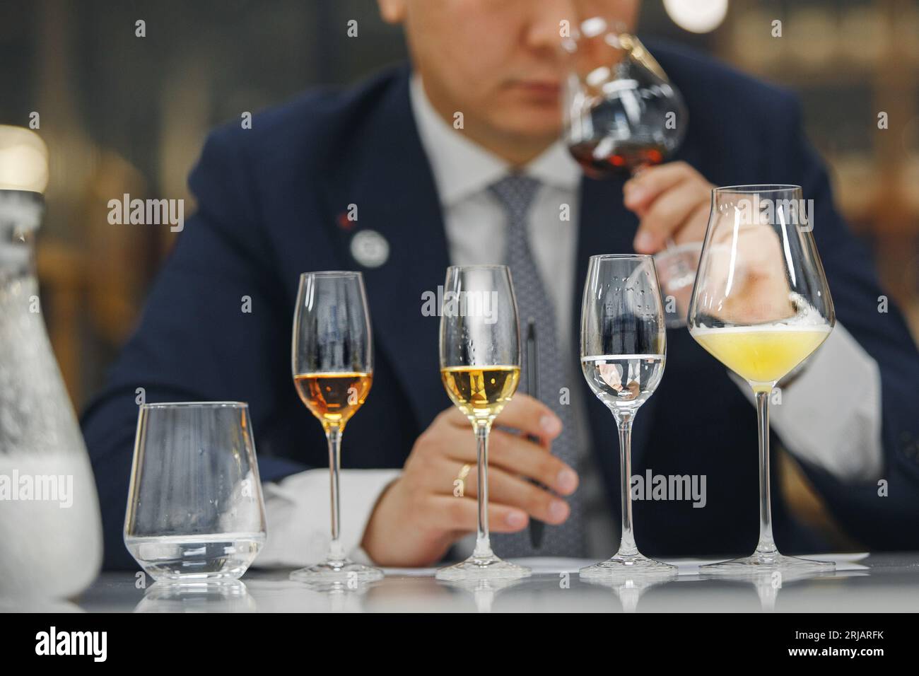 Beginner wine waiter sniffs alcoholic drink during blind tasting