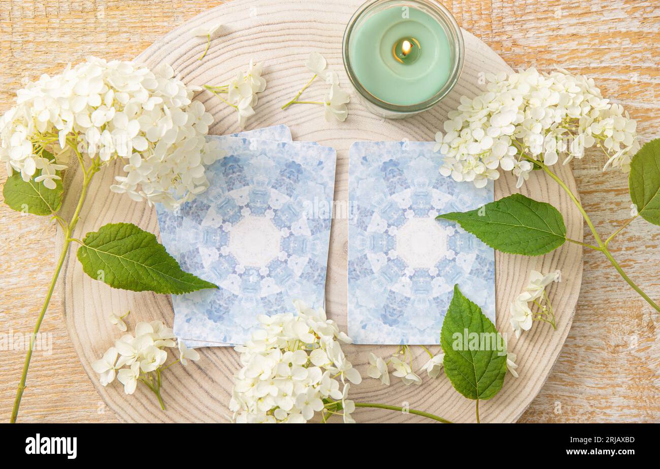 Deck with homemade divination Angel cards on wood table with hydrangea flower for decoration. Home indoors candle burning. Stock Photo