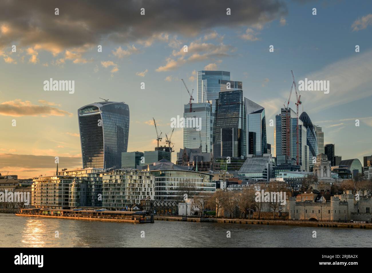 Three Quays Walk and the Tower of London are dwarfed by the high rise skyscrapers that line the River Thames at the City of London. Stock Photo