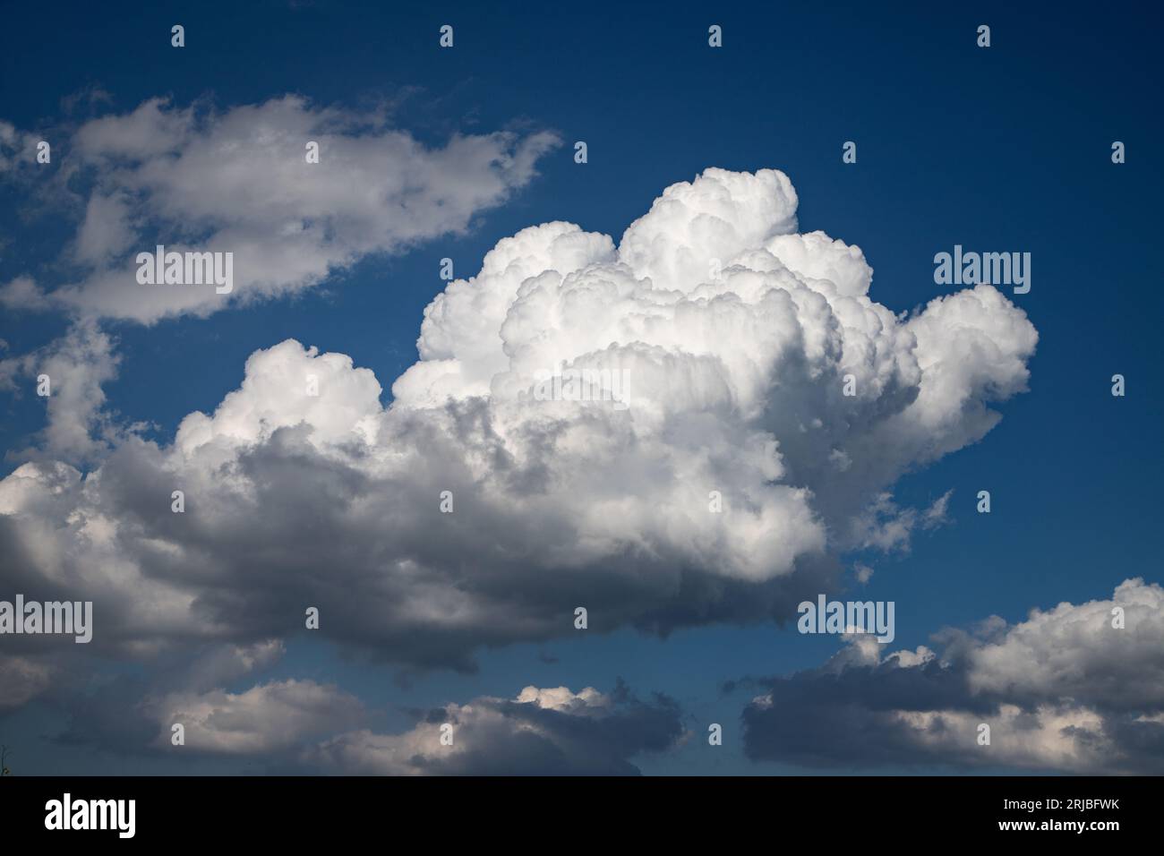 A white storm cloud looms ominously in the sky, heralding the approach of a tempes Stock Photo