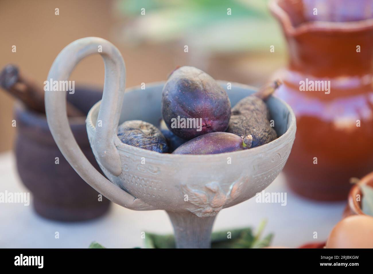 Clay cup full of mature figs. Ancient roman gastronomy concept Stock Photo