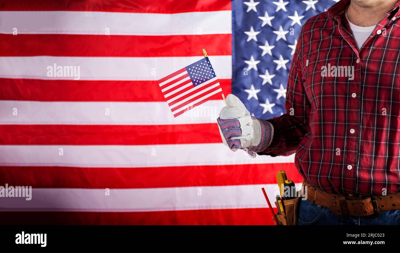 Carpenter in protective gloves and toolbelt with us flag labor day background Stock Photo