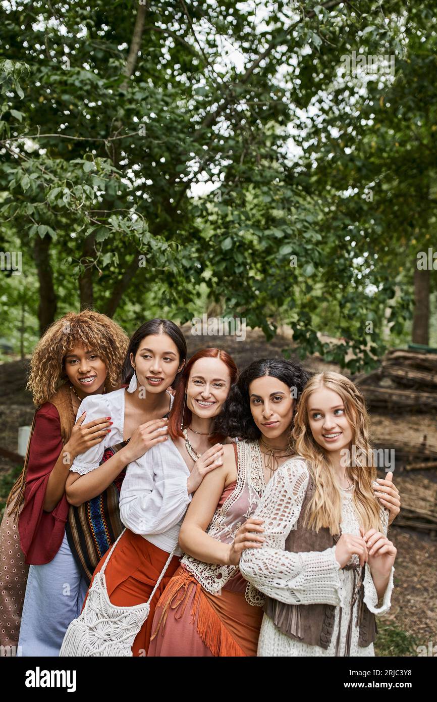 joyful multiethnic group of women looking at camera and hugging in ...