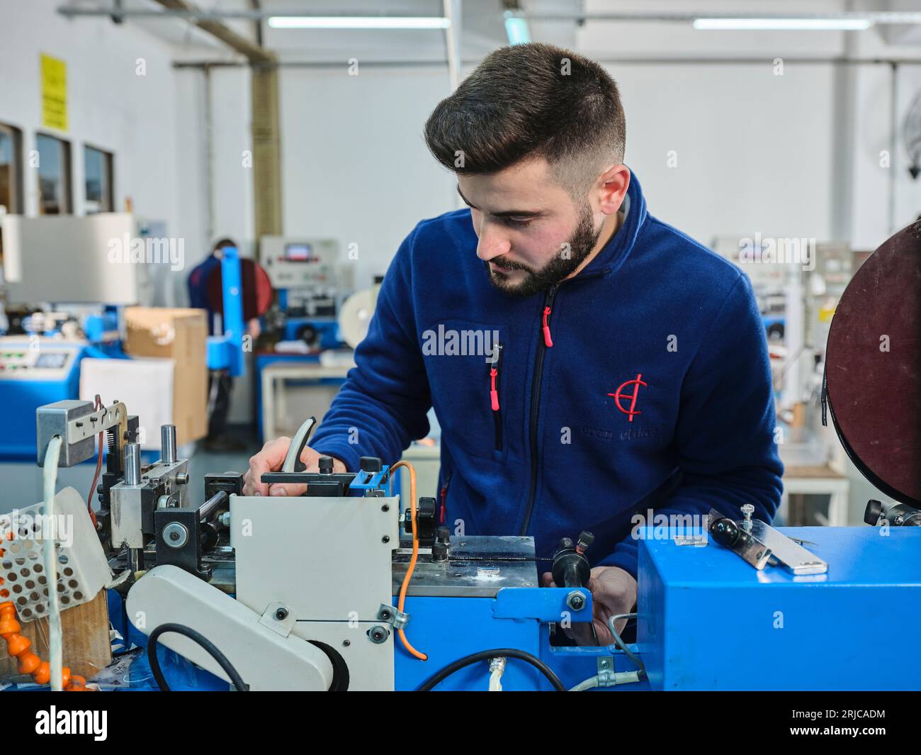 people working in a sticker printing factory. worker uses a stickier ...