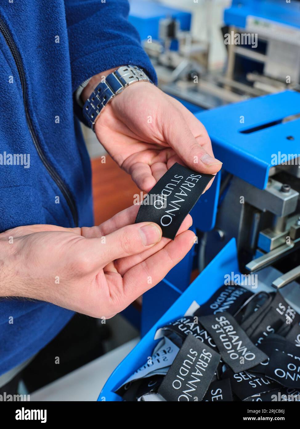 people working in a sticker printing factory. worker uses a stickier ...