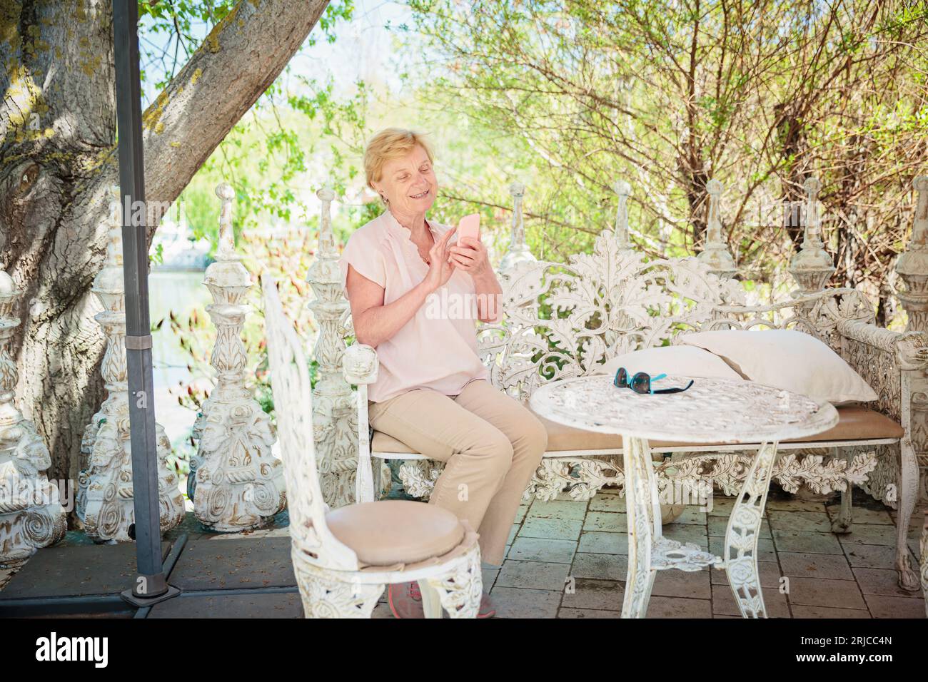 Mature attractive woman traveler sitting alone on the terrace of coffee ...