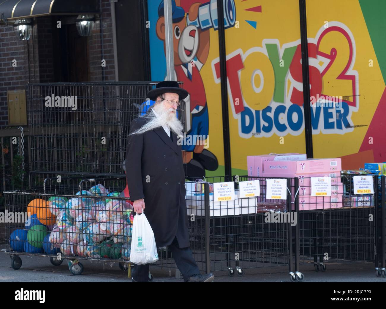 An orthodox Jewish man out shopping on has his beard blowing in the wind. On Hewes St. off Lee Avenue in Williamsburg, Brooklyn, New York. Stock Photo