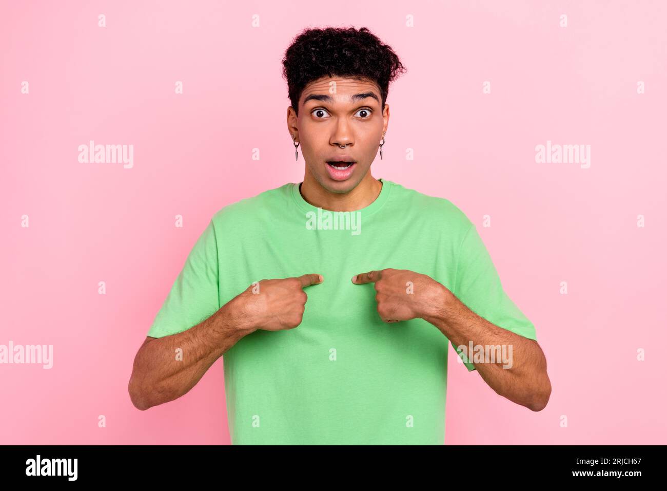 Photo of funky impressed man dressed green t-shirt open mouth pointing two fingers himself isolated pink color background Stock Photo