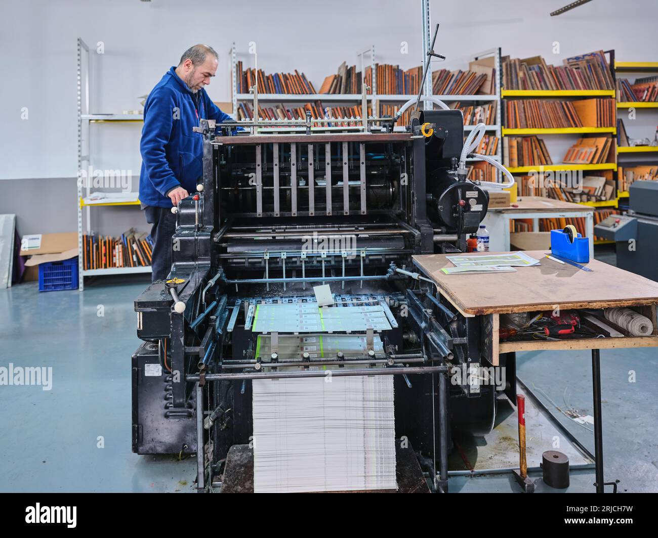 people working in a sticker printing factory. worker uses a