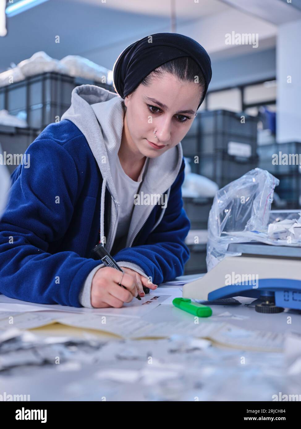 people working in a sticker printing factory. worker uses a stickier ...