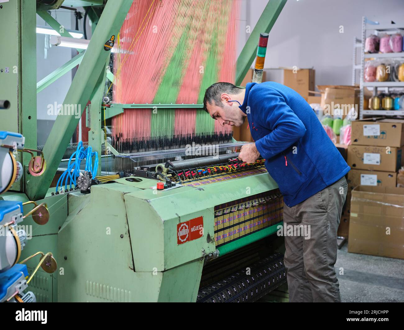 people working in a sticker printing factory. worker uses a stickier ...