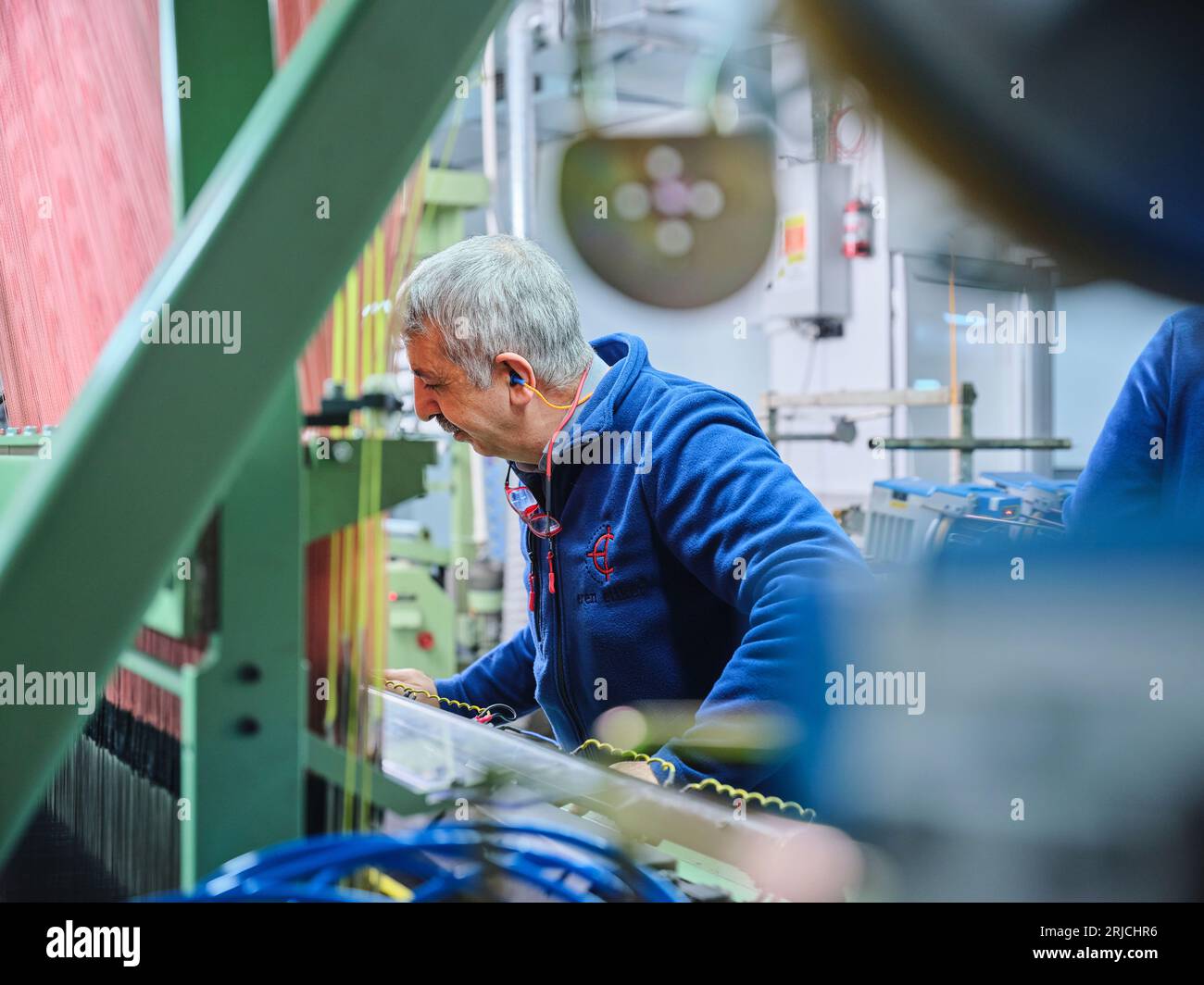 people working in a sticker printing factory. worker uses a stickier ...