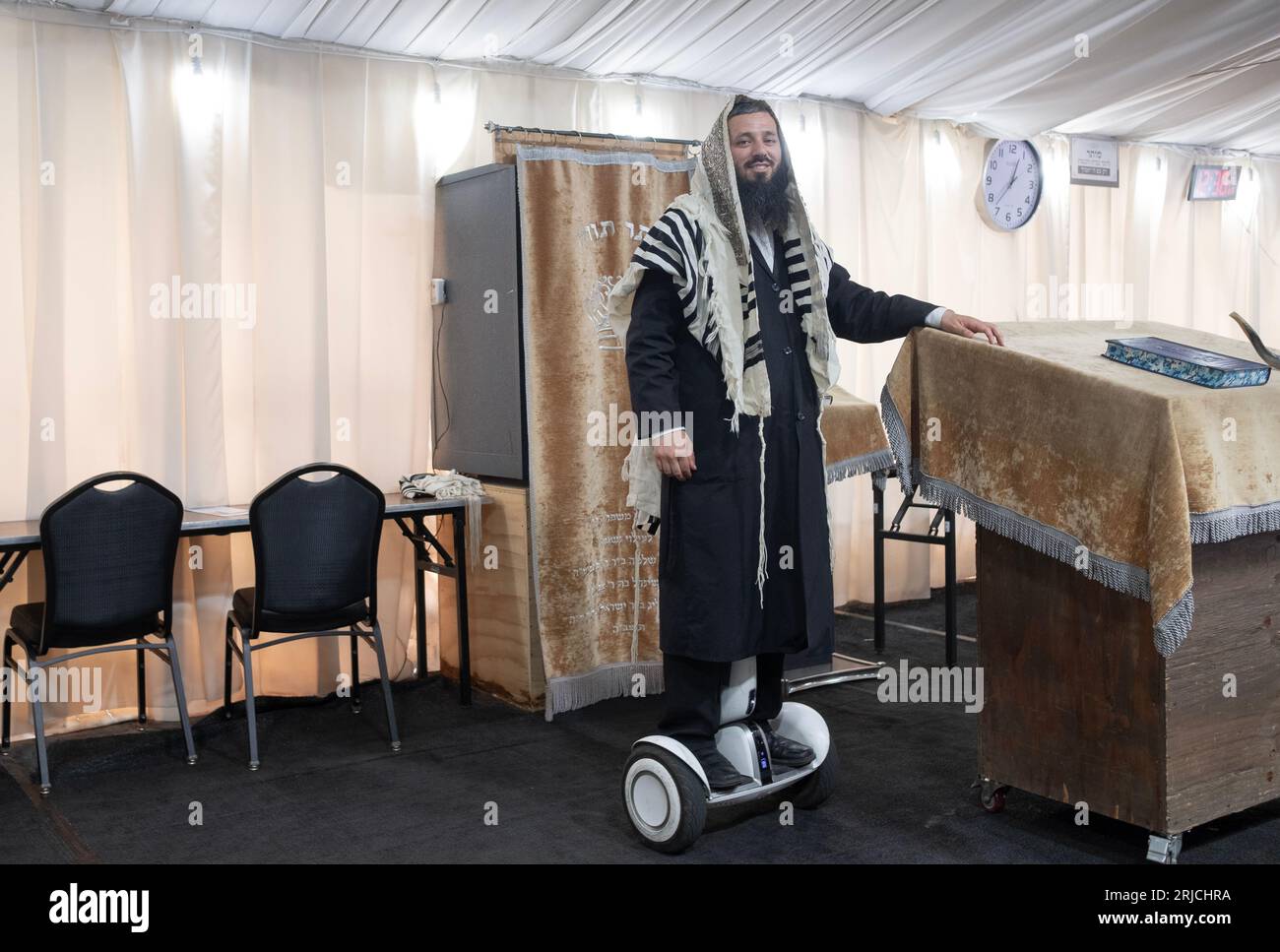 A sexton shammash at a synagogue with a few tents. His hoverboard