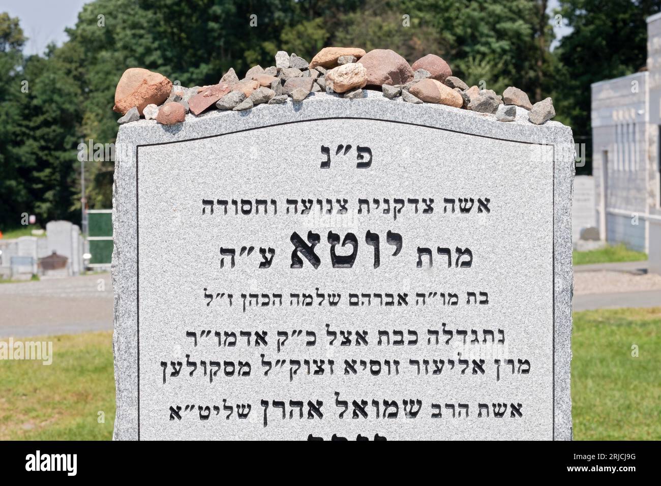 The headstone of and orthodox Jewish woman covered in stones. She was a