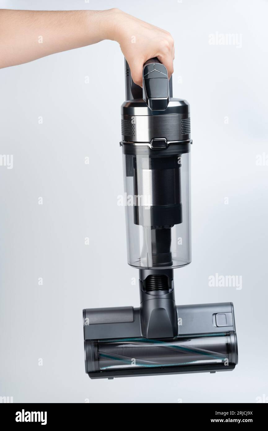 Hand hold gray vacuum cleaner with brush above top view isolated Stock