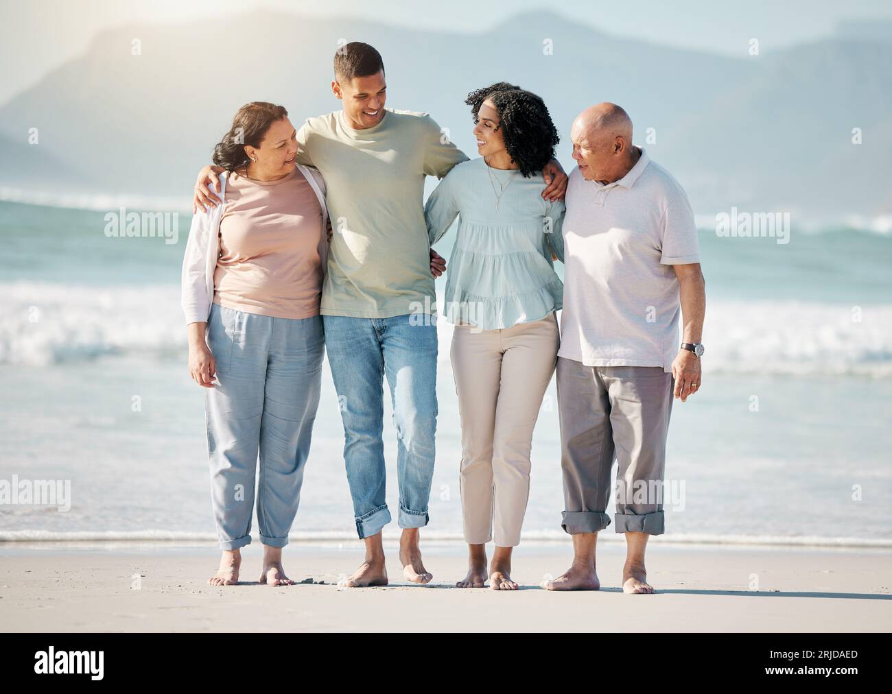 Happy family, beach and couple with senior parents hug, walk and bond ...