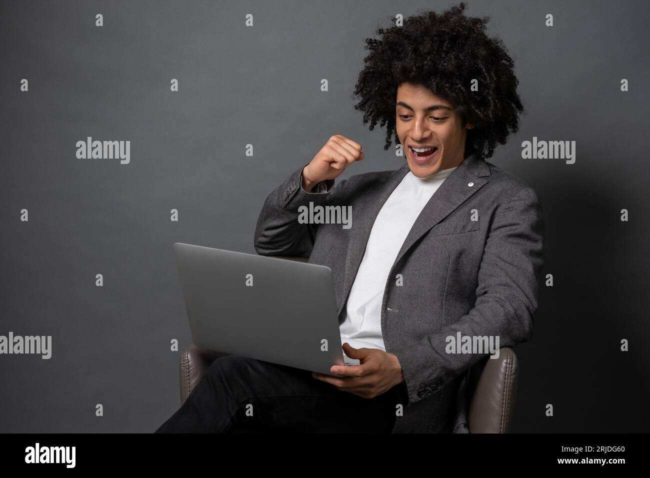 Curly-haired young manager working on laptop Stock Photo