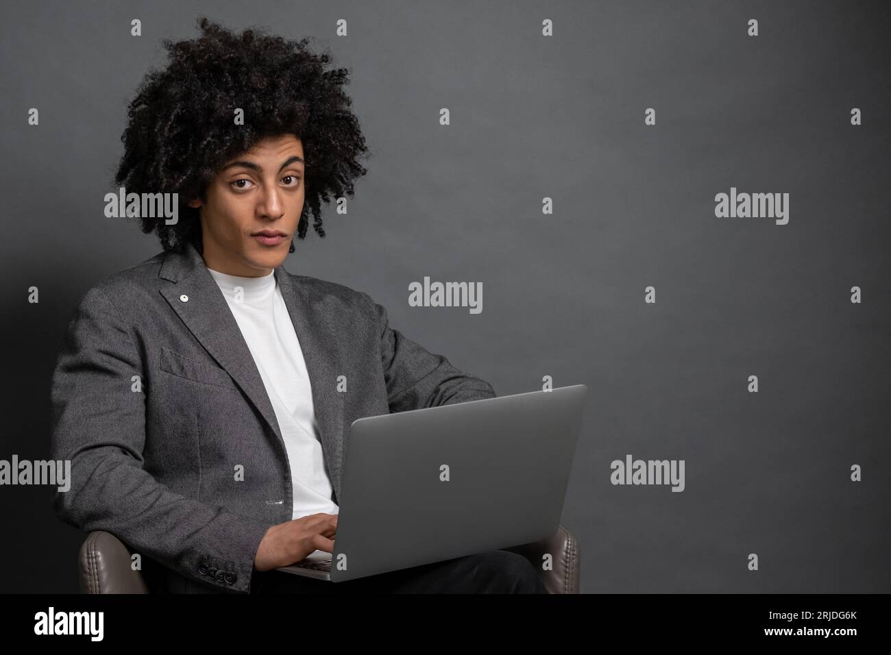 Curly-haired young manager working on laptop Stock Photo