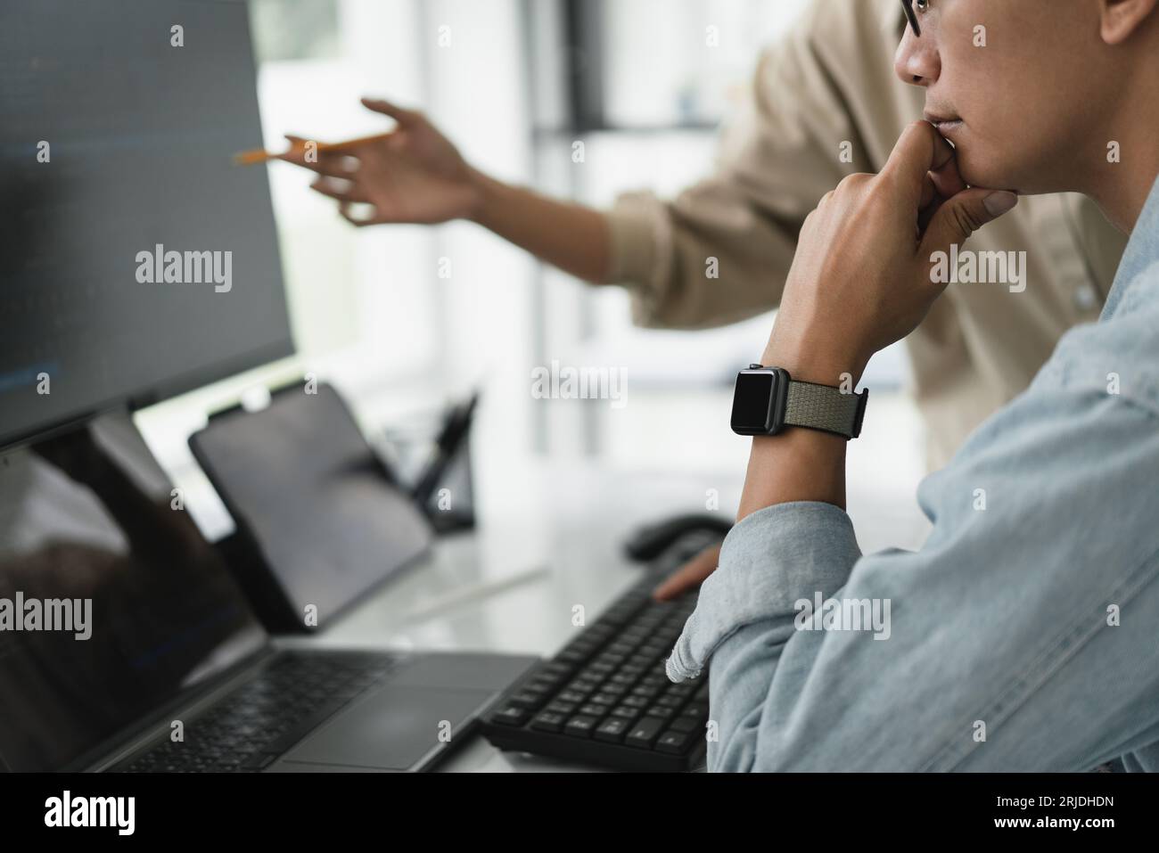 Two developer programmer discussing to checking code on monitor about ...