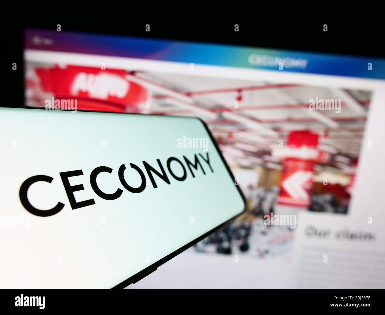 Smartphone with logo of German retail company Ceconomy AG on screen in front of business website. Focus on center-left of phone display. Stock Photo