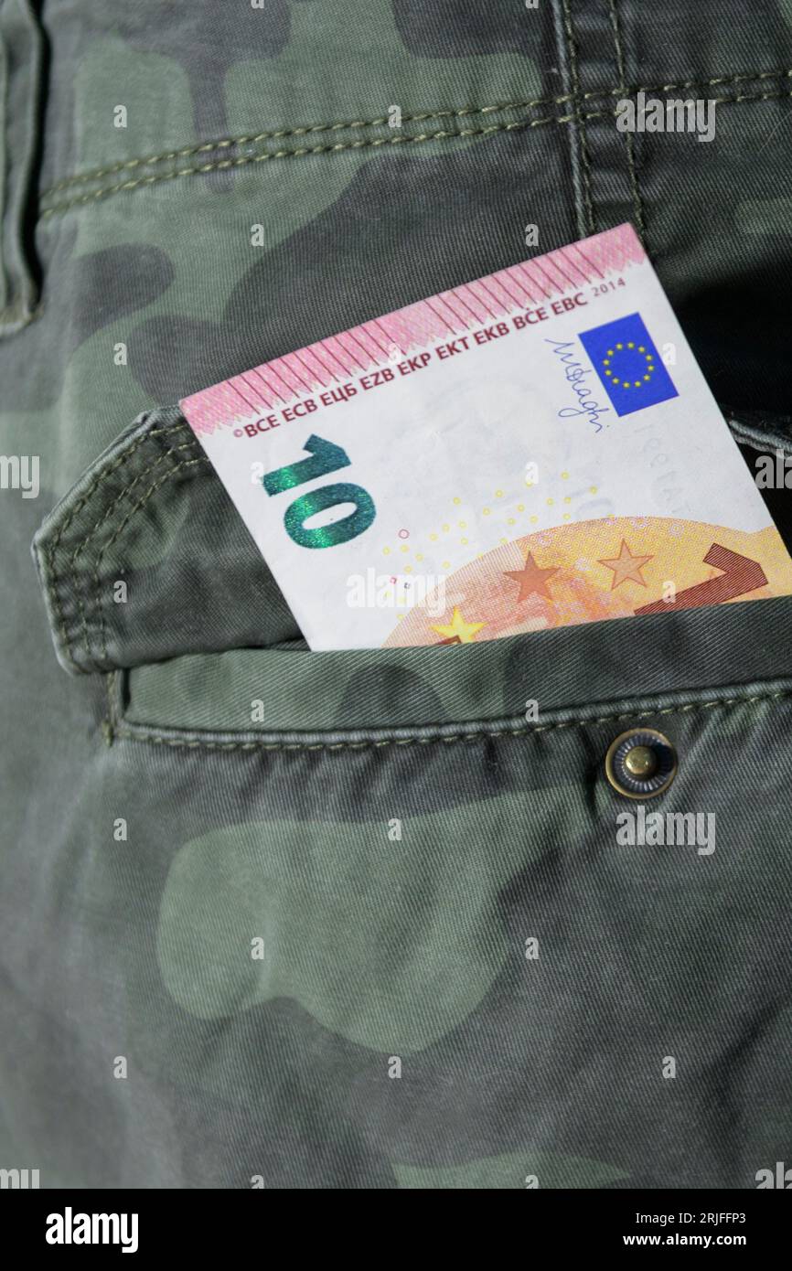 Ten euro in the back pocket of camouflage trousers Stock Photo