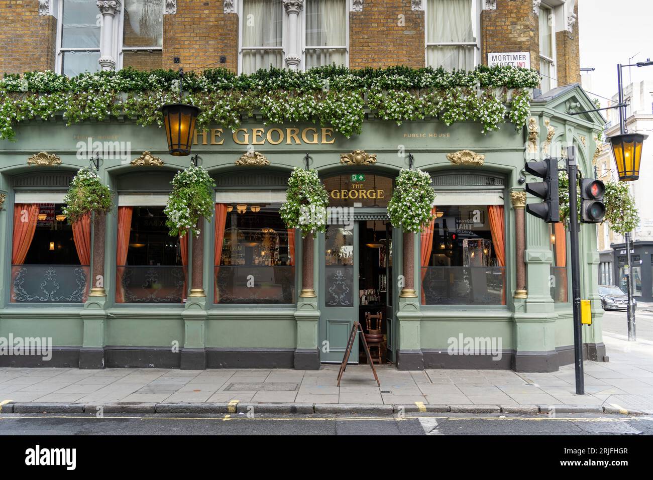 London, UK - October 2022: Flowers decorate the outside of the The George pub, a grade II listed public house in London's Mortimer Street Stock Photo