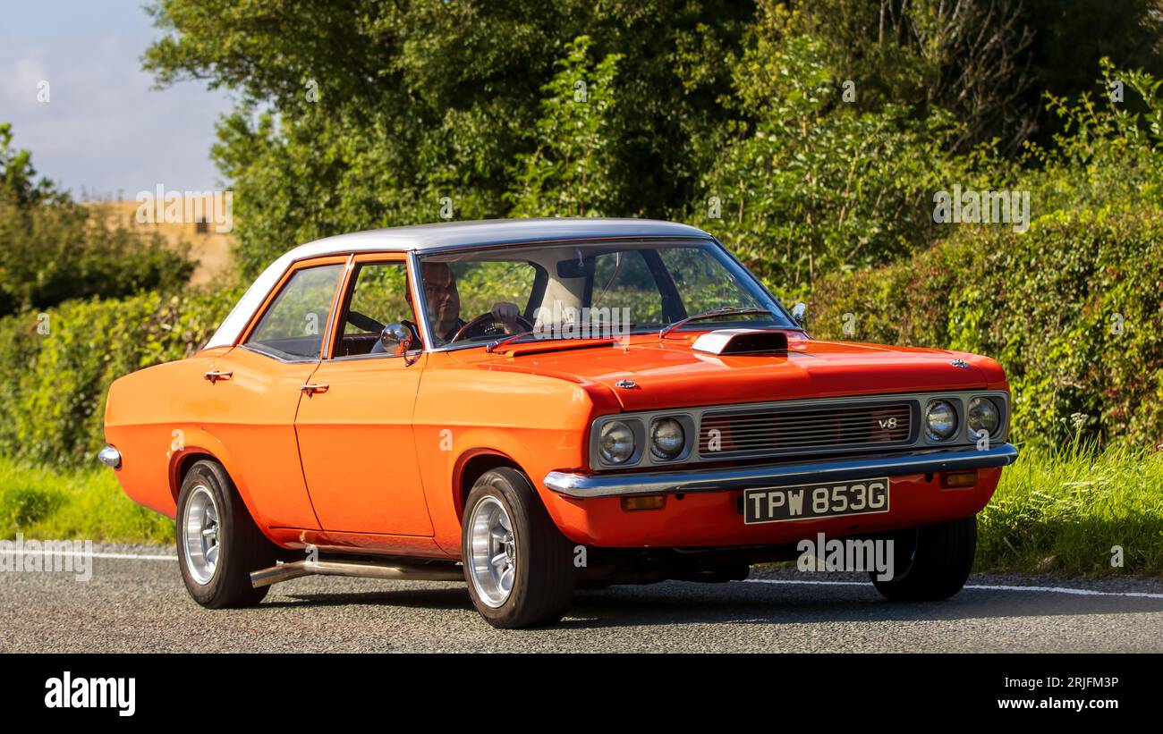 Woburn,Beds.UK - August 19th 2023: Orange 1969 Vauxhall Victor fitted with a 5000cc V8 engine, travelling on an English country road. Stock Photo