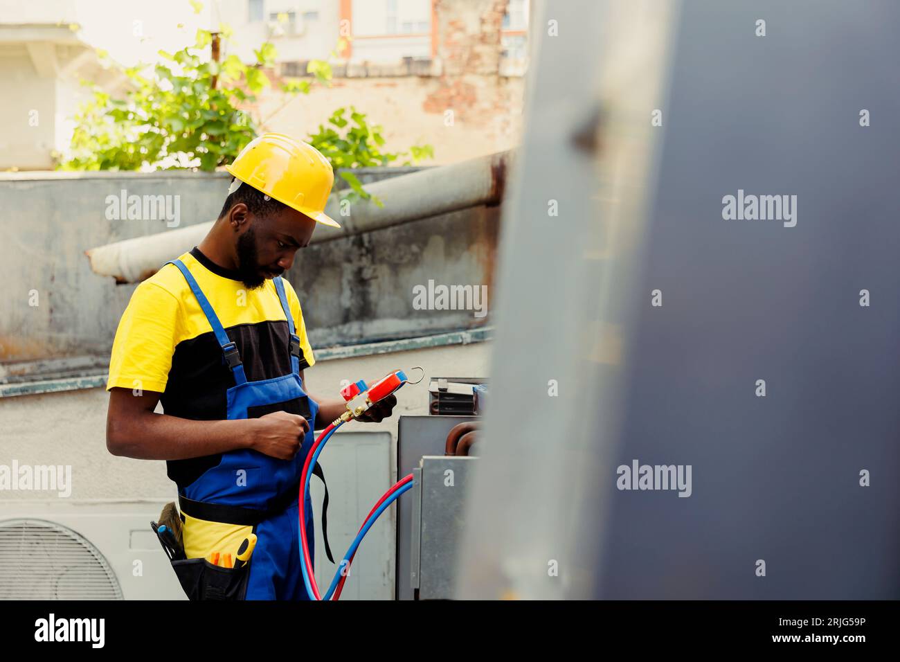 Experienced professional doing annual external air conditioner maintenance, getting equipment ready before starting work. Capable specialist using pressure measurement device to check freon levels Stock Photo