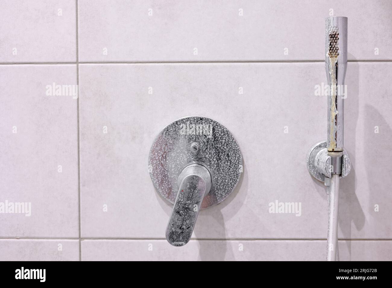 Dirty calcified shower mixer tap, faucet with limescale on it, plaque