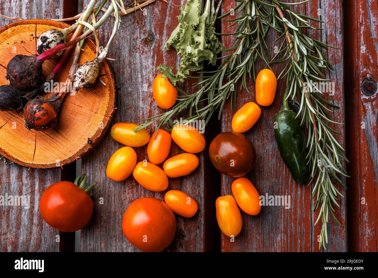 Vegetables yellow cherry tomatoes and red tomatoes on wooden table. Stock Photo