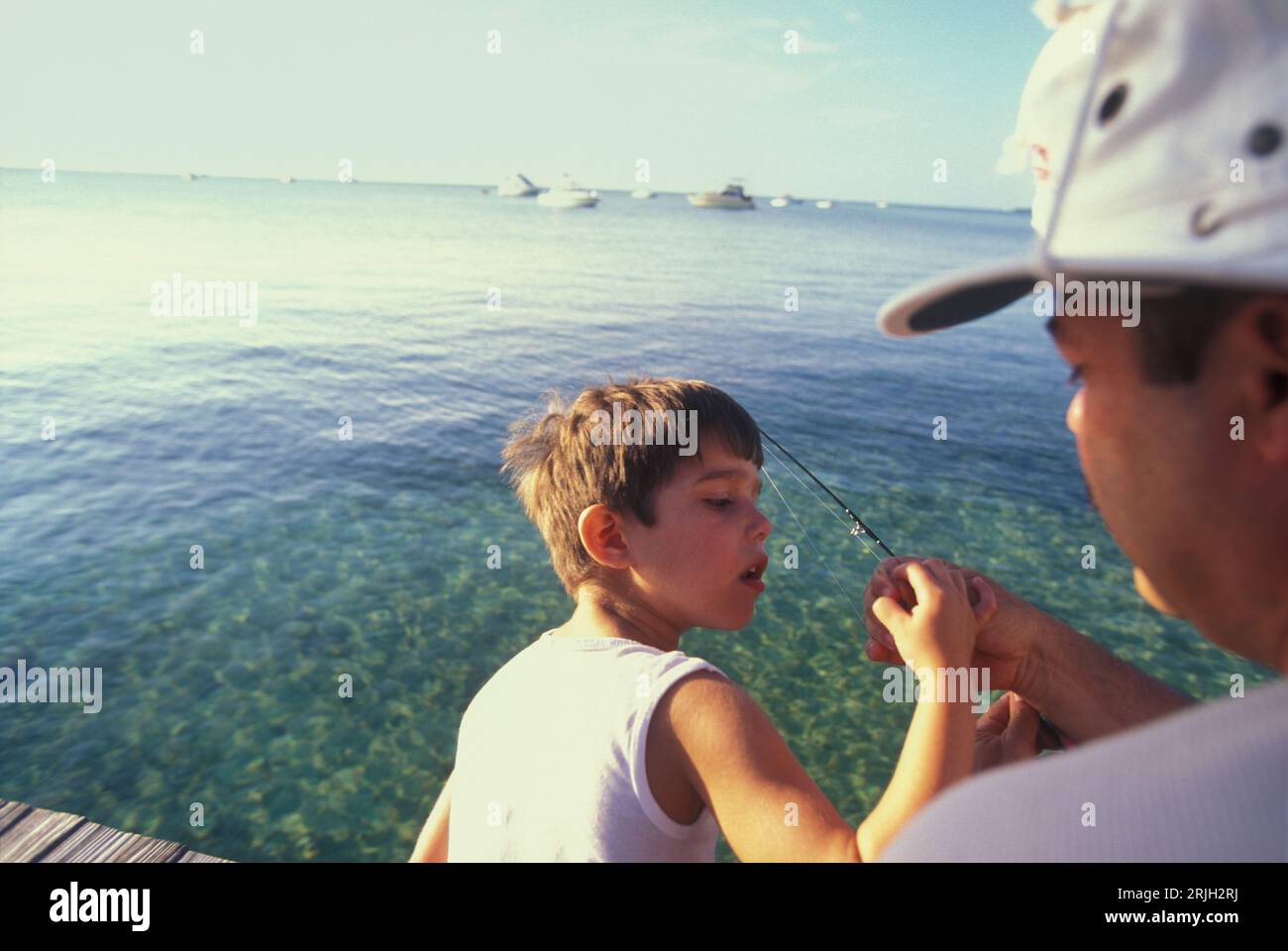 Father teaching son how to put the bait in the fishing hook, Florida Keys, USA Stock Photo