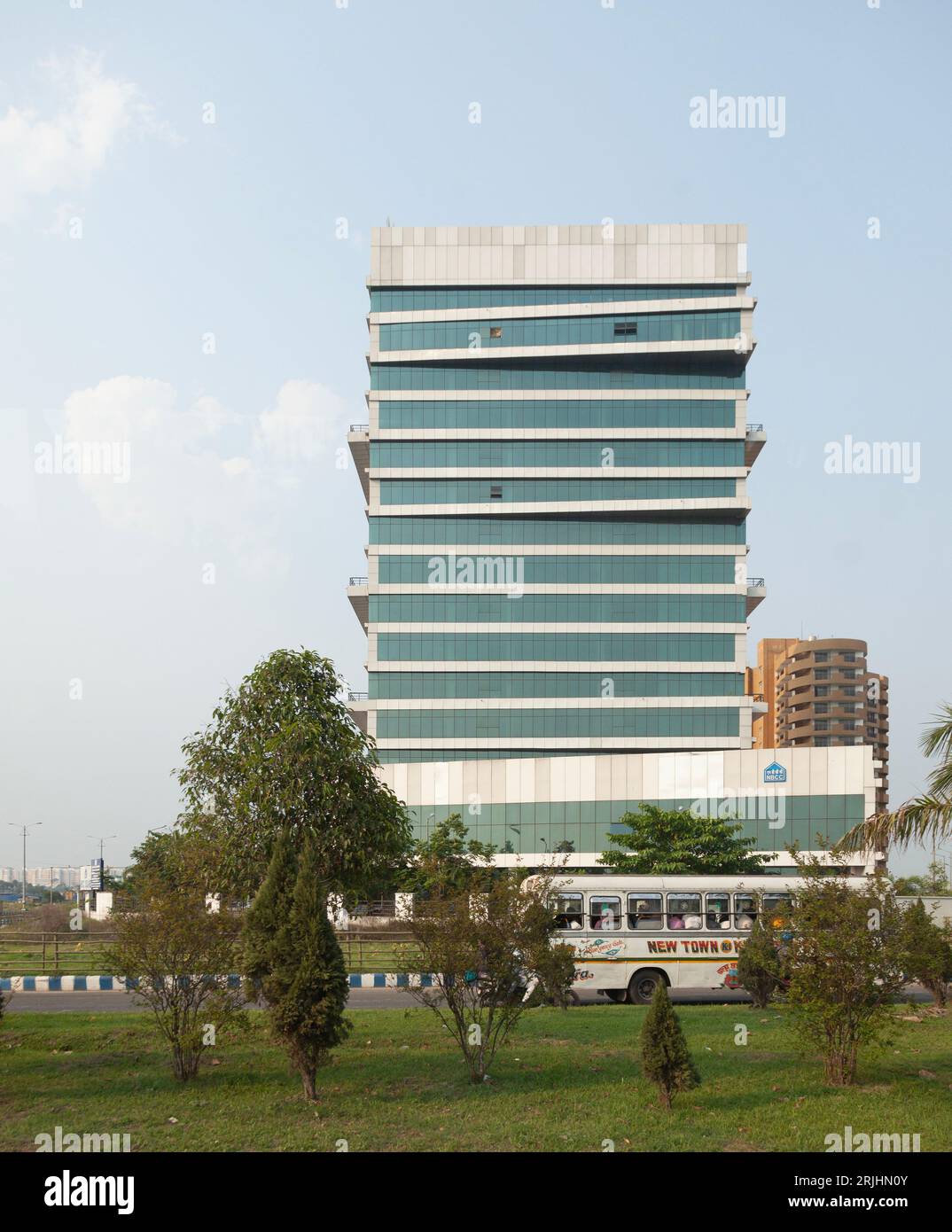 A crowded bus passes the NBCC Square, an office block in Rajarhat, New Town, Kolkata, India. Stock Photo