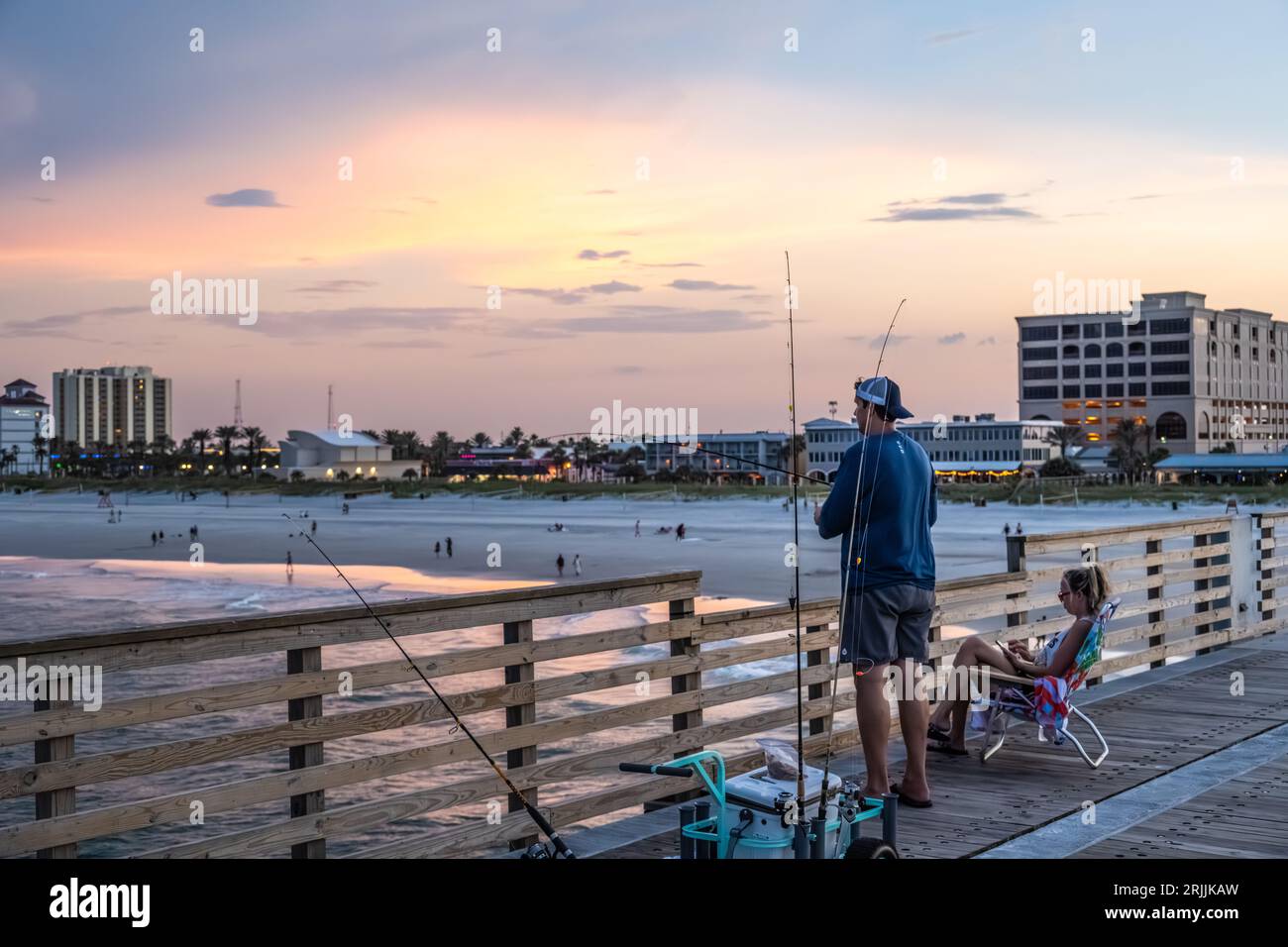 Saltwater fishing at sunset from the Jacksonville Beach Pier in Jacksonville Beach, Florida. (USA) Stock Photo