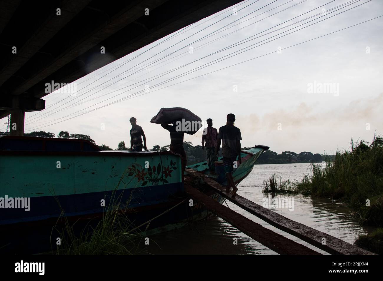 Wood husks are unloaded from the boat. This photo was taken on September 14, 2022, from Ruhitpur, Bangladesh Stock Photo