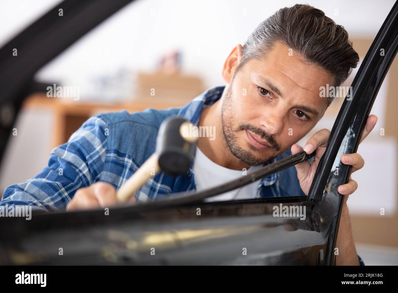 male panel beater using mallet on car bodywork Stock Photo Alamy