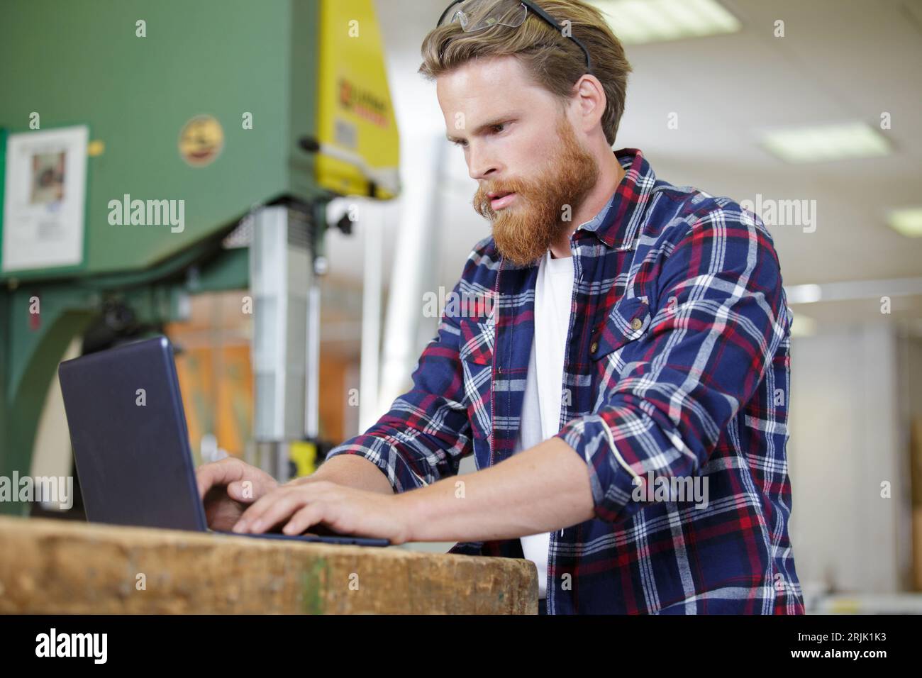 woodworker using laptop in his workshop Stock Photo