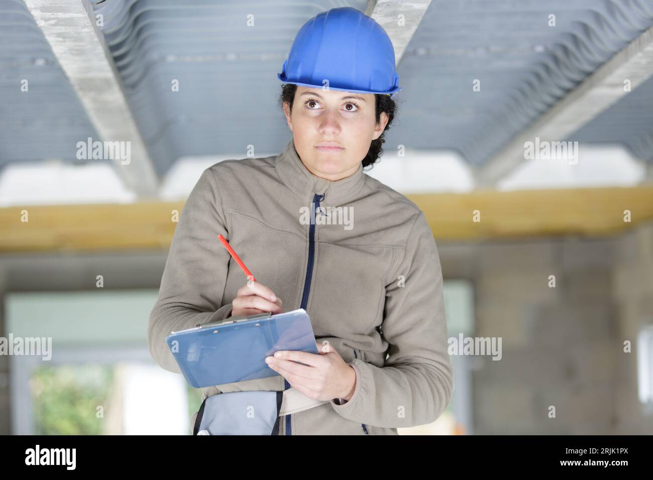 female contractor writing on clipboard Stock Photo