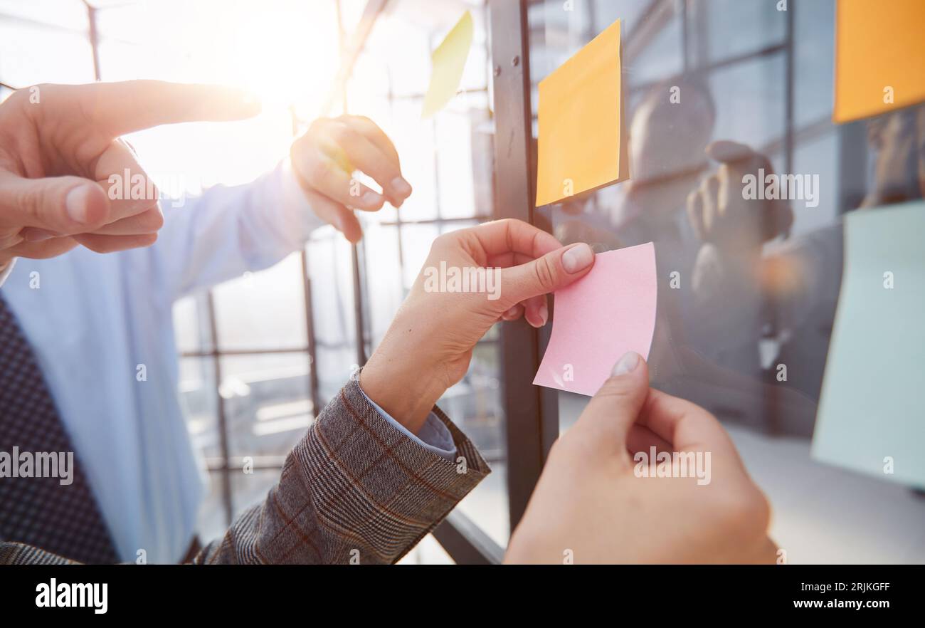 hand glues empty sticker on office window. Stock Photo